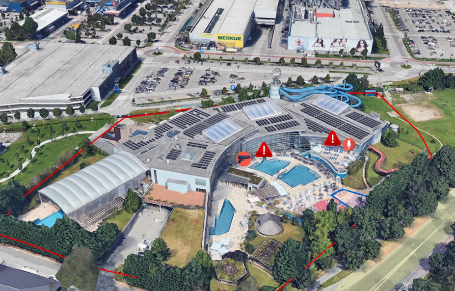 An aerial view of a building with a pool and buildings

Description automatically generated